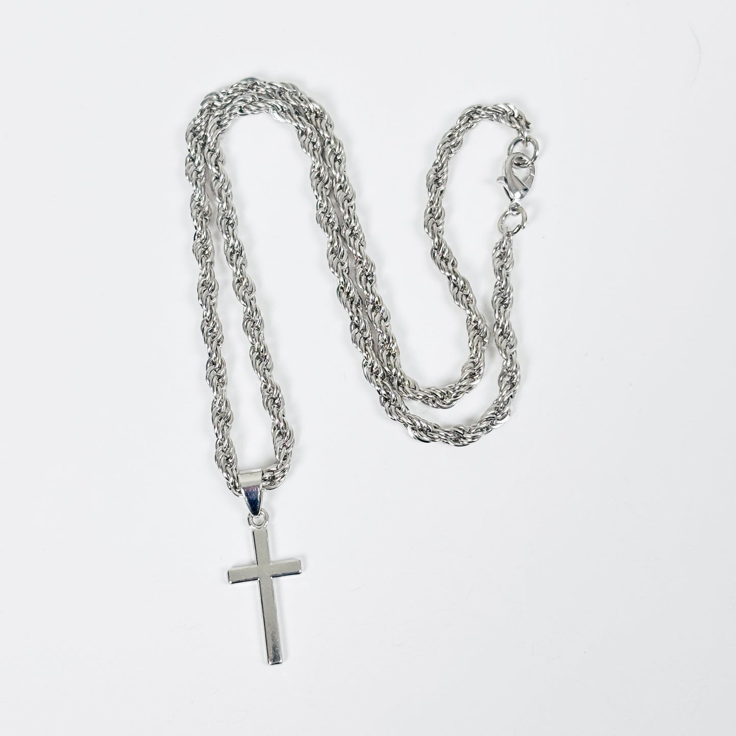 Silver chain necklace with a cross pendant on a white background