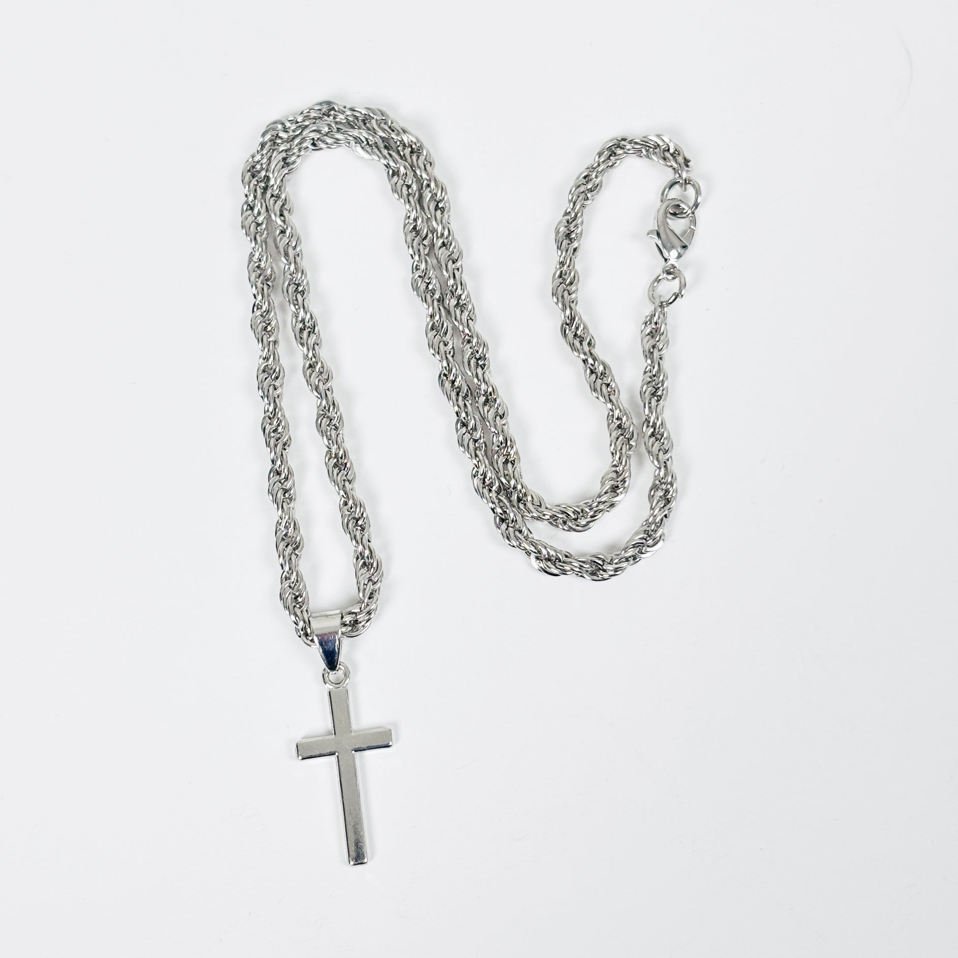 Silver chain necklace with a cross pendant on a white background