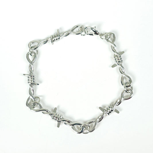 A silver-toned metal bracelet designed to look like twisted barbed wire, featuring sharp wire points and a lobster clasp closure, shown on a plain white background.