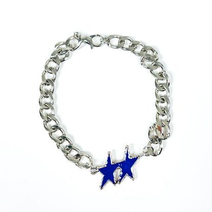 A silver-tone curb chain bracelet featuring a dangling blue star charm with a small white accent, shown on a plain white background.