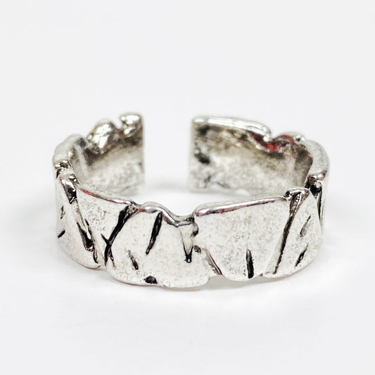 Silver ring with textured surface on a white background