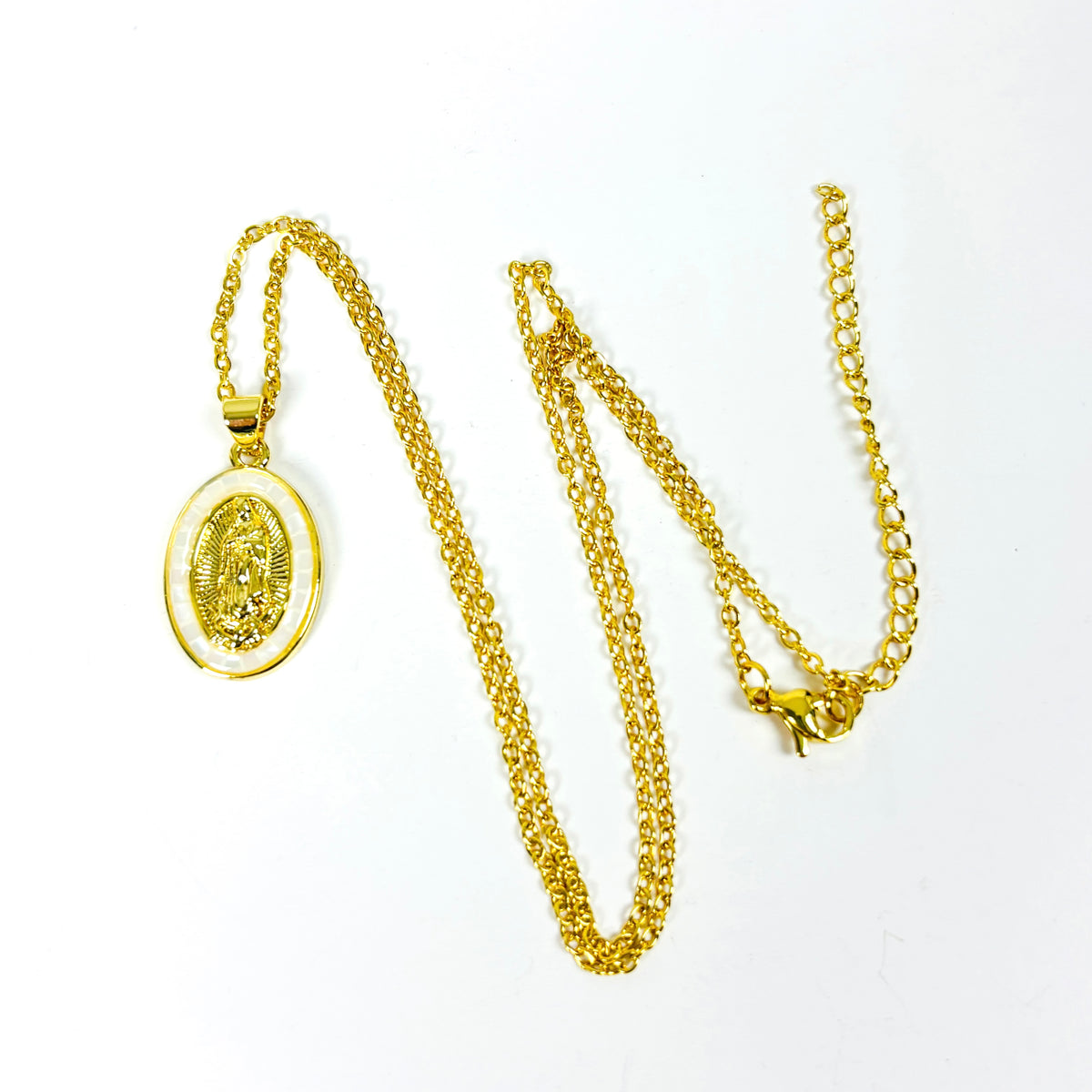 A gold chain necklace with an oval religious pendant featuring a detailed figure, displayed on a clean white background.