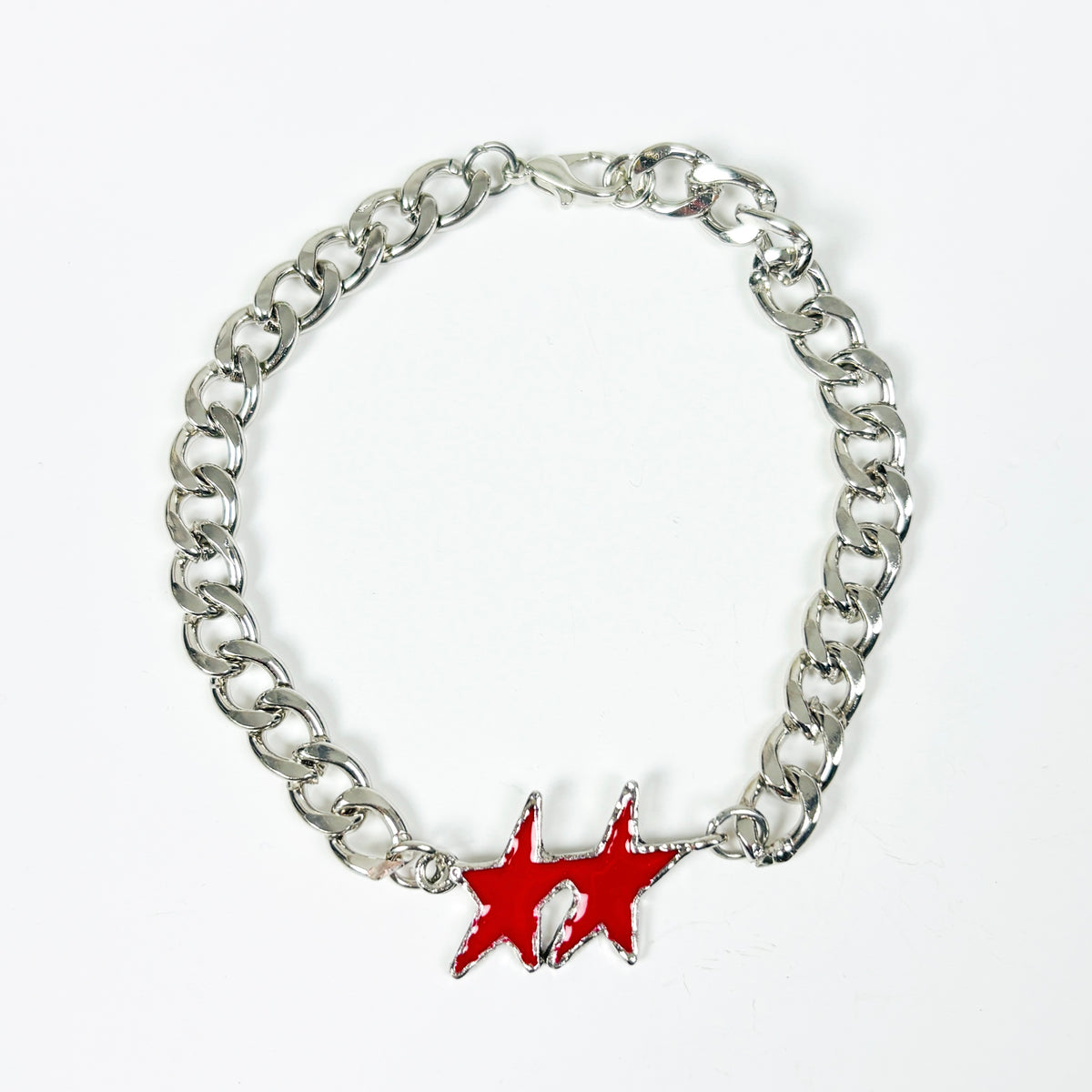 A silver-tone metal chain bracelet featuring a red enamel starburst charm in the center, displayed on a clean white background.