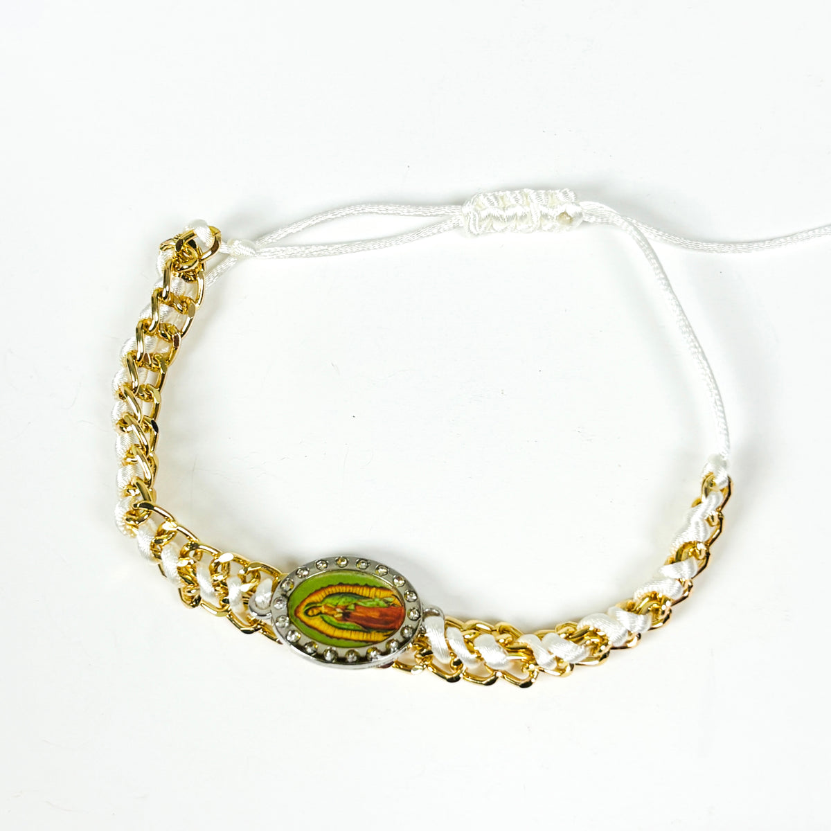 A gold chain bracelet with white braided cord accents and a central oval religious medallion featuring a green, yellow, and red design, set against a plain white background.