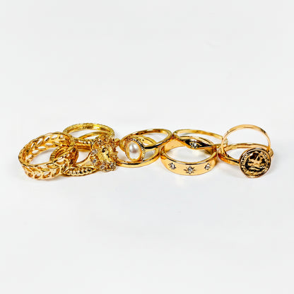 Set of gold rings with various designs on a light gray background