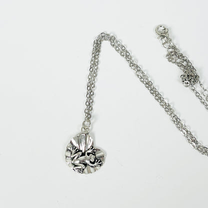 Silver necklace with a detailed pendant on a white background