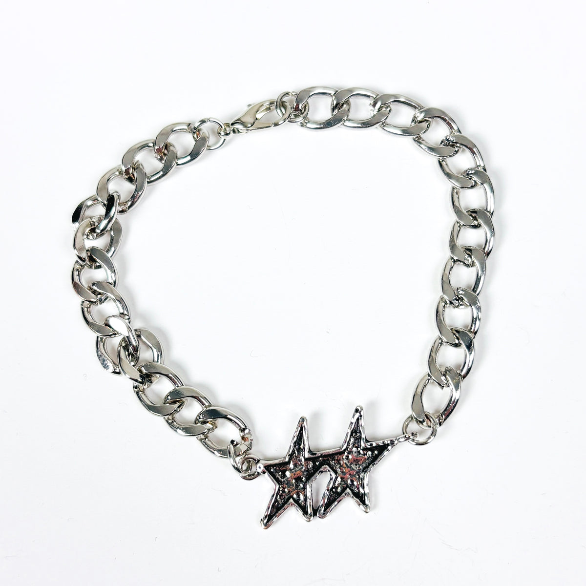 A silver-tone chain link bracelet featuring two interlocking star charms, one with a small pink stone accent, displayed on a clean white background.