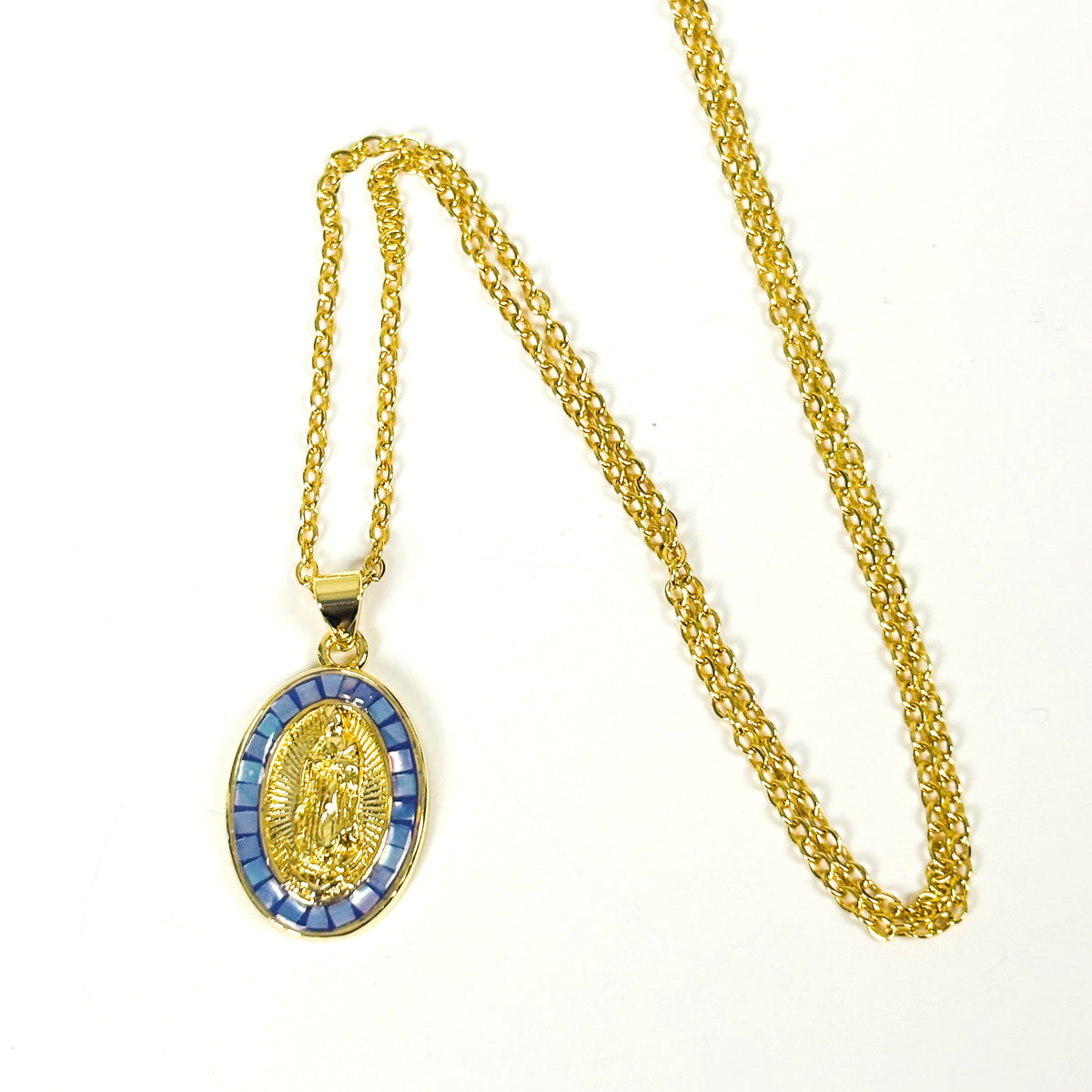 Gold chain necklace with an oval religious pendant featuring a gold figure surrounded by blue rectangular accents, displayed on a white background.