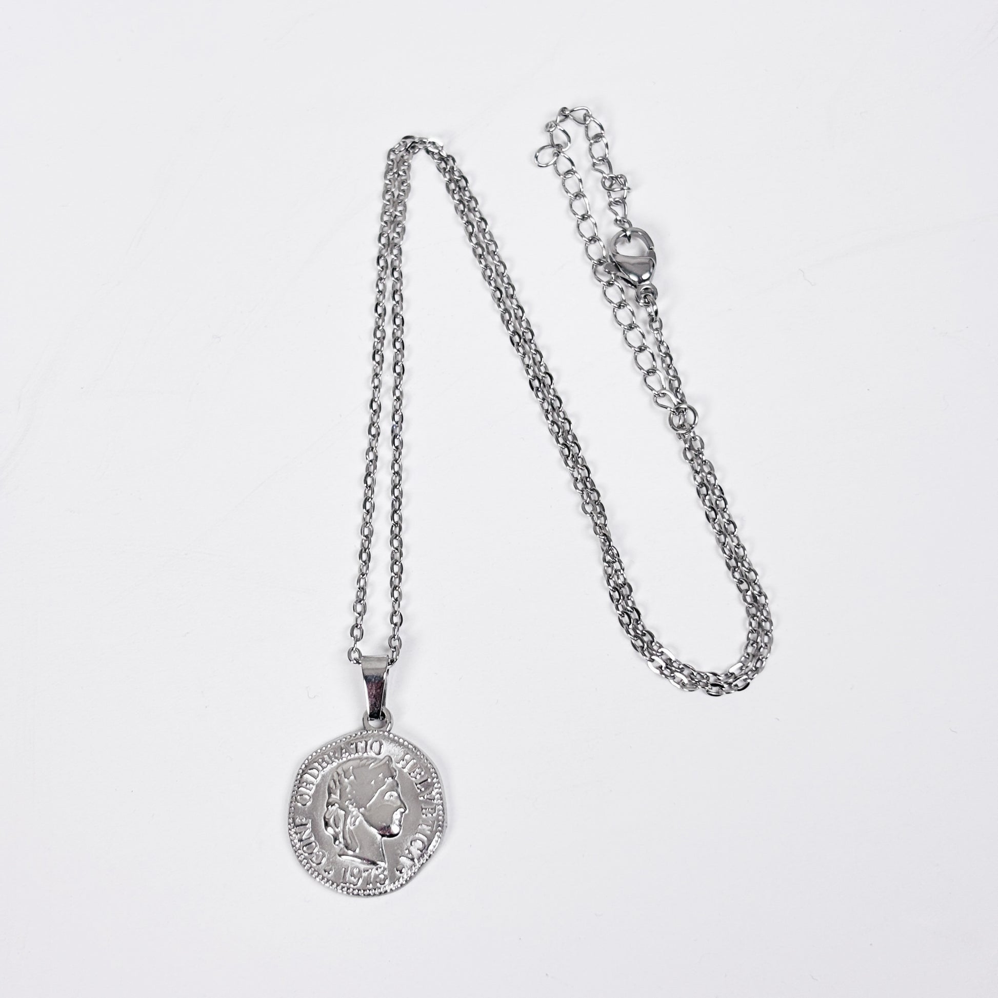 Silver necklace with a pendant on a light gray background