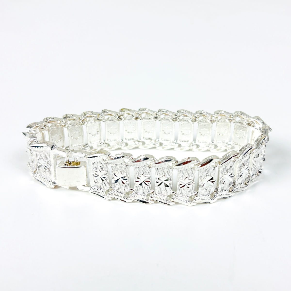 A silver bracelet with rectangular pavé-set clear stones and a starburst motif on each panel, shown on a plain white background.