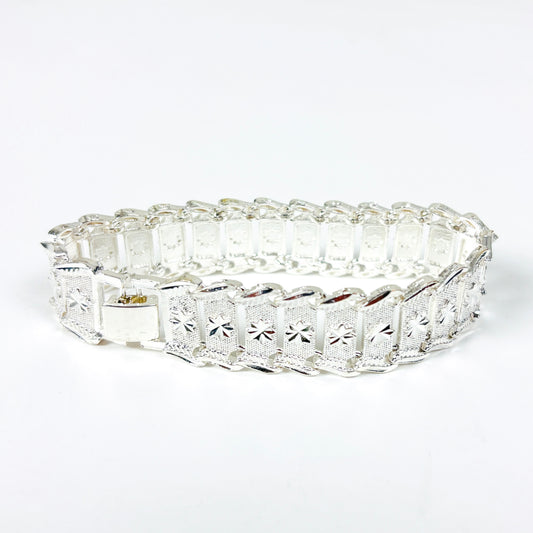 A silver bracelet with rectangular pavé-set clear stones and a starburst motif on each panel, shown on a plain white background.